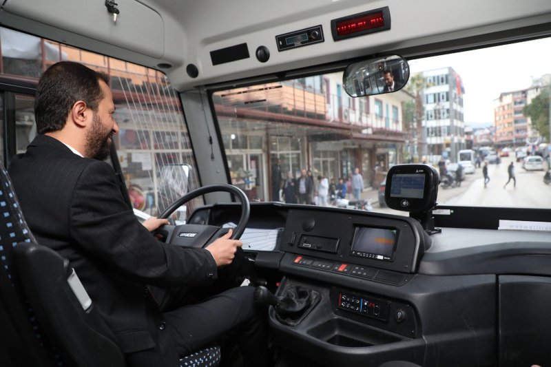 ŞEHİR İÇİ ULAŞIMDA HBB DÖNEMİ YAYLADAĞI’NDA BİR İLK: BELEDİYE OTOBÜSÜ Hatay Büyükşehir Belediyesi (HBB), toplu ulaşım hizmetlerini daha modern, güvenli ve konforlu hale getirmek amacıyla belediye uhdesindeki araçları oluşturduğu yeni güzergâhlarda vatandaşların hizmetine sunuyor. HBB Ulaşım Dairesi Başkanlığı, Yayladağı ilçesinde artan nüfus yoğunluğundan dolayı oluşan vatandaşların ulaşım ihtiyaçlarına cevap vermek için şehir içinde oluşturduğu yeni güzergâhta satın alınan yeni araçlarla hizmet vermeye başladı. Daha önce şehir içi ulaşım hattının bulunmadığı Yayladağı’nda bir ilk olan 18 kilometrelik toplu ulaşım hattı ilçe merkezindeki tüm mahalleleri kapsayacak ve HATAYKART elektronik ödeme sistemine entegre bir şekilde çalışacak. İlk Turu Başkan Yalçın Attı Yeni hattan dolayı mutluluğunu ifade eden Yayladağı Belediyesi Başkanı Mehmet Yalçın, güzergâhtaki ilk turunda bizzat şoför koltuğuna geçerken “bugün HBB’nin Yayladağı’nda bir ilke imza atışına şahit oluyoruz. Aşağı yukarı 18 kilometre ve şehir merkezindeki mahallelerde şehir içi hattımız yoktu. Seçimlerden hemen sonra çalışmalara başladık.” dedi. HBB Ulaşım Dairesiyle beraber güzergâhları belirleyerek durakları konuşlandırdıklarını ifaden Başkan Yalçın, “Büyükşehir Meclisinden kararımızı geçirdikten Ulaşım Koordinasyon Merkezinden de (UKOME) karar geçti ve şehir içi ulaşım hattımız hizmete giriyor. HBB Başkanı Mehmet Öntürk ve emeği geçen herkese teşekkür ediyorum.” diyerek çalışmayla ilgili memnuniyetini belirtti. Ulaşım Çilesi Son Buldu Yayladağlı öğrenciler okullarına gidip gelirken daha güvenli ve konforlu bir ulaşım imkanına kavuştuklarını ve toplu ulaşımla ilgili tüm sıkıntılarının son bulduğunu belirterek HBB Başkanı Mehmet Öntürk ve Yayladağı Belediyesi Başkanı Mehmet Yalçın’a teşekkür ettiler. Başkan Öntürk’ten Bayram Hediyesi: Ücretsiz Ulaşım Ulaşım Dairesi Başkanlığı yetkilileri, Büyükşehir Başkanı Mehmet Öntürk’ün “bayramda toplu ulaşımın ücretsiz yapılması” talimatıyla arefe gününden başlayarak Ramazan Bayramı süresince Hatay Büyükşehir Belediyesi’ne ait otobüslerin ücretsiz hizmet vereceğini açıkladı.