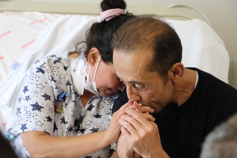 Hataylı Çiftin Sıra Dışı Aşkı Yaşamasına yüzde 1 ihtimal verilen çiftin sıra dışı aşkı - Çocukken diyalizde tanışan çift, 2 kez böbrek nakli olarak hayata tutundu (İHA) - Antalya'da 15 yıl boyunca diyalize girip kuzeninin bağışladığı böbrekle yaşama tutunan, 5 yıl sonra ise böbreğinde tekrar yetmezlik gelişince yüzde 1 uyum ihtimalinin gerçekleşmesiyle hayata tekrar tutunan Ali Özkul, çocuk yaşta diyalize girerken tanıştığı ve babasından aldığı böbrekle yaşama tutunan Dilber Özkul ile 4 yıl önce evlendi. Çiftten Dilber Özkul ise henüz evliliğinin ilk yılında tekrar börek nakli olmak zorunda kaldı. Yüzde 3 uyum ihtimali bulunan talihsiz kadın, kadavradan böbrek nakliyle tekrar yaşama kavuştu, çiftin yüzleri tekrar güldü. Hatay'da yaşayan Ali Özkul (47) ve Dilber Özkul (40), yaşadıkları böbrek sorunu nedeniyle çocukken diyalize başladı. 1993 yılında Ali Özkul 15 yıl boyunca diyalize girdikten sonra kuzenini bağışladığı böbrekle hayata tutundu, 5 yıl sonra ise nakil böbreği çalışmamaya başlayınca tekrar diyalize girmek zorunda kaldı. Vücudu antikor üreten Ali Özkul'un yüzde 99 çıkan PRA'sı, tekrar uyumlu böbrek bulma ihtimalini yüzde 1'e düşürdü. Sağlık Bakanlığı kadavra bekleme listesine alınan Özkul, 2015 yılında uyumlu çıkan donörle tekrar yaşamam tutunup, Denizli'de Diş Hastanesi'nde çalışmaya başladı. Biri yüzde 1, diğeri yüzde 3 ihtimal Yıllar önce çocukken tanıştığı Ali Özkul ile yolları ayrılan Dilber Özkul ise, 19 yıl boyunca diyalize girdikten sonra 2007 yılında babasından böbrek nakli oldu. Nakil sonrası 15 yıl boyunca sağlıklı bir şekilde yaşamını sürdüren Dilber Özkul'un yolu tekrar Ali Özkul ile kesişti. 2022 yılında evlenip mutlu bir yuva kuran çiftten Dilber Özkul'un henüz evliliğinin ilk yılında böbreği iflas etti. PRA'sı yüzde 97 olup yüzde 3 uyum ihtimali bulunan kadına, 1 Mayıs'ta Sağlık Bakanlığı kadavra listesinde yer alan bir böbrek uygun çıktı. Ellerini sımsıkı tuttular Medical Park Antalya Hastane Kompleksi'nde hemen ameliyata alınan Dilber Özkul, tekrar yaşama tutunmanın mutluluğunu bu sefer kendisiyle aynı durumu yaşayan eşiyle paylaştı. Birbirlerinin ellerini sımsıkı tutan çiftin mutluluğu ise gözlerine yansıdı. Bağışın önemine vurgu yaptı Nakil süreciyle ilgili açıklamalarda bulunan Medical Park Hastane Kompleksi'nden Genel Cerrahi Uzmanı Prof. Dr. İbrahim Aliosmanoğlu, çiftin sağlık durumlarının iyi olduğunu belirtti. Kadavra bağışın önemine dikkat çeken Prof. Dr. Aliosmanoğlu, "Gencecik bir insanın yeniden hayata dönmesi ve iş hayatına topluma kazandırılması sadece canlı vericiyle olmayacak bir durum. Çünkü bu şans çok çok düşüktü ve kadavra bağışı sayesinde bu hasta kurtarılmış oldu. Ülkemizde ciddi sayıda aslında beyin ölümü tanısı konuluyor. Ama maalesef bunların çok az kısmının organları bağışlanıyor. 2 bin bağıştan ortalama 300-400 arası sadece aile izniyle bağışa dönüşüyor ve bunun da yine bir kısmını kullanamıyoruz. Daha düşük miktarını nakil olarak gerçekleştiriyoruz. Özellikle bekleme listelerinde yaklaşık 30 bin civarı diyalize giren hasta bir umutla böbrek naklini bekliyor. Bu yüzden kadavra bağış oranını artırdığımızda ve özellikle bir beyin ölümü tanısı konulup da aile izni sayısını artırdığımızda organ bekleyen hastalara daha büyük fayda sağlayacağız ve onlara daha çok umut olacağız" dedi. "Her zaman çare var" Nakil sonrası sağlığına tekrar kavuşmanın mutluluğunu yaşayan Dilber Özkul ise, "Hiç umutsuzluğa kapılmadım ve inanıyordum. Çok şükür, sağlığıma kavuştum. Herkes azmetmeli, pes etmemeli. O kadar mutlu oldum ki. Umut olsun istiyorum gerçekten. İkinci nakil olsun, üçüncü nakil olsun. Bunları kesinlikle atlamasınlar. Her zaman çare var. Yani bu rahatlığa kavuştuğum için çok şükür. Herkesin kadavraya yazılmasını istiyorum" dedi. "Daha güzel günler yaşayacağız" Eşiyle birlikte yolunun yıllar sonrası kesişmesiyle ayrı bir mutluluk yaşadığını da dile getiren Özkul, "Eşimle gençken diyalize birlikte giriyorduk. Ondan sonra eşimin Ankara'ya yolu düştü. Sonra yollarımız ayrıldı. Sonradan tekrar burada birleşti. Ve burada daha mutlu olduk. Daha güzel günler yaşayacağız inşallah" ifadelerini kullandı. "O duyguları anlatamazsınız" Ali Özkul da duygularını anlatmakta güçlük çekerek, "O duyguları anlatamazsınız, çok sevinçli ve mutluyum. Eşimle aynı mutluluğu paylaşıyoruz" diye konuştu.