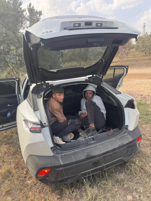 Araçların bagajlarından göçmen çıktı (Fotoğraflı) Ahmet Arslan HATAY (İHA) - Hatay'da polis ekipleri tarafından gerçekleştirilen yapılan çalışmalarda 37 göçmen şahıs tespit edilirken, 9 şahıs mahkemece tutuklandı. Operasyonlarda hınca hınç göçmen doldurulan araçların bagajlarından göçmen çıkmasıysa dikkat çekti. Hatay Emniyet Müdürlüğü görevlilerince göçmen kaçakçılığıyla mücadele çalışmaları aralıksız sürüyor. Polis ekipleri tarafından 30 Nisan - 16 Mayıs tarihleri arasında Antakya ve İskenderun'da durdurulan 7 farklı araç içerisinde yapılan aramada; üzerlerinde herhangi bir tanıtma kartı olmayan ve ülkemizde geçerli oturma izni olmadığı anlaşılan 37 göçmen şahıs tespit edildi. Olayların 12 şüphelisi yakalanırken, bu şahıslardan 9'u sevk edildikleri adli makamlarca tutuklanarak cezaevine gönderiler. Diğer 3 şahıs hakkında ise adli işlem yapıldı. Mağdur göçmen şahıslar işlemleri sonrasında İl Göç İdaresi Müdürlüğüne teslim edildi. Ayrıca olaylarda kullanılan araçlara el konularak 278.352 TL idari para cezası uygulandı. Öte yandan, araçların bagajlarının dahi göçmenle doldurulması dikkat çekti.