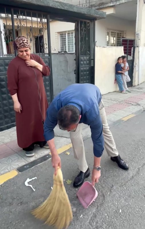 Belediye başkanı sokağı süpüren kadının elinden süpürgeyi alıp kendi süpürdü