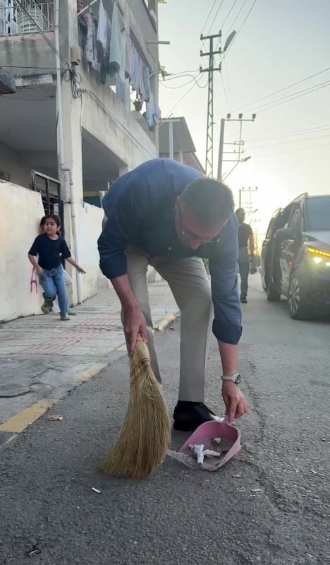 Belediye başkanı sokağı süpüren kadının elinden süpürgeyi alıp kendi süpürdü