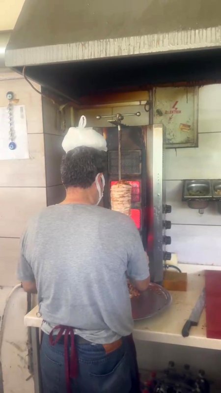 Dönerci ustası kavurucu sıcakta, ateş karşısında kafasına buz torbası koyarak serinlemeye çalıştı
