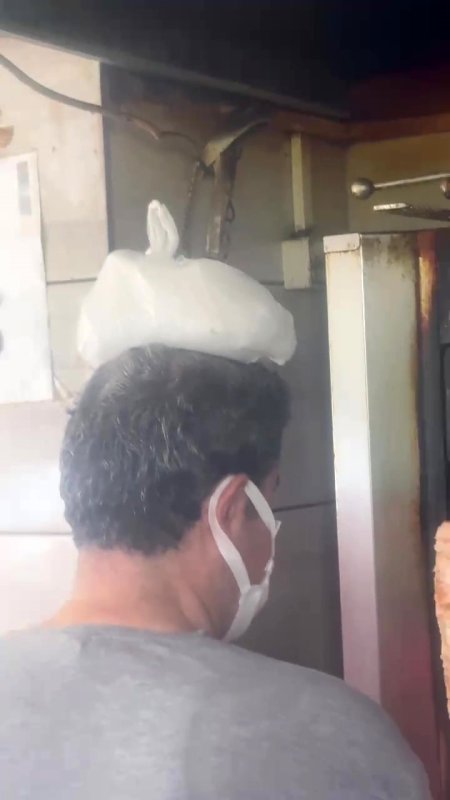 Dönerci ustası kavurucu sıcakta, ateş karşısında kafasına buz torbası koyarak serinlemeye çalıştı