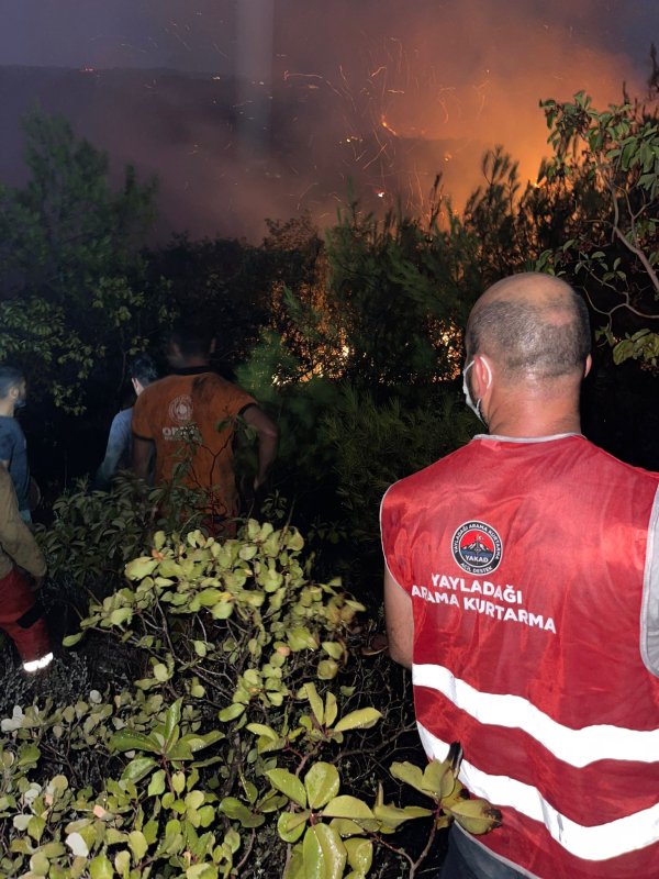 Hatay'da orman yangını sürüyor... Alevlere müdahale 10. saatte devam ediyor (Fotoğraflı - Görüntülü) Arzu Kübra Doğan HATAY (İHA) - Hatay’da çıkan orman yangınına müdahale 10. saatte gece karanlığında devam ediyor. Yangın, saat 15.30 sıralarında Yayladağı ilçesi Arslanyazı Mahallesi'nde ormanlık alanda çıktı. Alevlere Hatay Valiliği koordinesinde; Orman Bölge Müdürlüğü, Hatay Büyükşehir Belediyesi, AFAD, destek illerin ekipleri, Yayladağı Belediyesi ile TAMP kapsamında görevli kurum ve kuruluşların personelleri ile müdahale devam ediyor. Olay yerinde alevlere müdahale eden 69 araç ve yaklaşık 200 personel bulunuyor. Öte yandan gündüz saatlerinde yangına 2 askeri helikopter müdahale etti. Ekiplerin 10. saatte müdahaleye devam ettiği yangında alevlerin günün ağarmasıyla kontrol altına alınması bekleniyor.