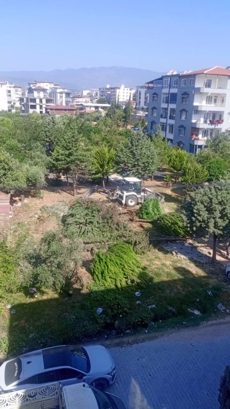 Hatay'da Parktaki ağaç katliamına tepki Parktaki ağaçların sökülmesine vatandaşlardan tepki HATAY (İHA) - Hatay'da taziye evi yapılacağı söylenerek Defne Belediyesi ekiplerince park içerisindeki çam ağaçlarının iş makinesiyle sökülmesine depremzede vatandaşlar tepki gösterdi. Deprem sonrası sosyal ve yeşil alanların eksikliğine dikkat çeken Necla Özdemir, "Depremden çıktık artık yaşamak istiyoruz, her yer gitmiş bari ağaçlara dokunmasınlar" dedi. Defne ilçesi 474. Sokak üzerinde bulunan yeşil alana taziye evi yapılacağı söylenerek Defne Belediyesi iş makineleri ve ekipleri tarafından 8 çam ağacı söküldü. Duruma tepki gösteren vatandaşlar, ekiplerin ağaçları iş makineleriyle sökmelerinin önüne geçmek amacıyla müdahale ettiler. Sökülen ağaçlar, kamyonlara yüklenerek bölgeden götürüldü. Depremin ardından bölgede sosyal ve yeşil alan sayısının azaldığına dikkat çeken vatandaşlar, Defne Belediyesi'ne seslenerek yapılacağı söylenen taziye evinin başka bir noktaya yapılmasını talep ettiler. "Biz bir ağaç dikmek için neler yapıyoruz ve şimdi burada katliam yapıyorlar" Ağaçların sökülmesine tepki gösteren Semira Şah, "Burada çam ağaçları vardı, kocaman kocaman zeytin ağaçlarımızda vardı. Muhtar sabah göndermiş iş makinelerini koparmış ağaçları. Mahalle sakinlerinin haberi olmadan ağaçları sökmüşler. Buraya taziye evi yapılmak isteniyor ama biz istemiyoruz. Bütün komşular karşı sadece ben değilim. Ağaç bir nefestir, nefesimizi kesiyorlar. Biz bir ağaç dikmek için neler yapıyoruz ve şimdi burada katliam yapıyorlar. Burası ağaç doluydu, şu an boş. Bu bir katliamdır, parkımız ve ağaçlarımız bize yeter. Zaten ağaç kalmadı ama biz buraya ağaç dikeceğiz" dedi. Çocukların parkta vakit geçirerek sosyalleştiğine dikkat çeken anne Necla Özdemir, depremin ardından bölgedeki yeşil alanların yetersizliğine dikkat çekerek "Burada 8 ağaç vardı. Sabah 09.00 sıralarında uyandım ve dışarı çıkıp baktım. Kepçe ağaçları deviriyordu. Eşim aşağıya indi, ben de kayda aldım. Birkaç kişi inene kadar devirdiler ağaçları, biz durduktan sonra ağaçları sökmeyi bıraktılar. Kamyona doldurdular ve bırakıp gittiler. Defne Belediyesi personeli ve belediyeye ait araçlardı. Buraya taziye evi yapılacakmış, biz taziye evi istemiyoruz. Burası park, yeşillik ve şehrimiz depremden etkilenmiş. Çocuklarımız rahat etsin diye konteynerden geldik. Çocuklarım şurada rahat nefes alıyor, oynuyor. Depremden çıktık artık yaşamak istiyoruz, her yer gitmiş bari ağaçlara dokunmasınlar. 8 ağacı koparıp gittiler, biz müdahale etmesek daha keseceklerdi. Ağaçları Defne Belediyesi personeli kopardı" dedi. Öte yandan Çekmece Mahalle Muhtarı Ali Kaya, proje alanından sökülen ağaçların başka alana taşınacağını ifade ederek taziye evinin vatandaş talebi olduğunu söyledi.