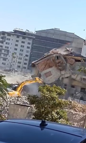 Yıktığı binanın altında kalmaktan saniyelerle kurtuldu, korku dolu anlar kamerada (Fotoğraflı) Ramazan İlın - Arzu Kübra Doğan HATAY (İHA) - Hatay’ın Defne ilçesinde 5 katlı binanın yıkımının gerçekleştiği esnada iş makinesinin, yıktığı binanın altında kalmaktan saniyelerle kurtulduğu anlar kameraya yansıdı. Kahramanmaraş merkezli depremlerde büyük yıkımın yaşandığı Hatay’da mahkeme süreci tamamlanan binalar yıkılmaya devam ediyor. Depremin vurduğu Defne ilçesi Sümerler Mahallesi’nde mahkeme süreci tamamlanan 5 katlı bina, iş makinesinin darbesiyle kontrollü olarak yıkıldı. 5 katlı binanın kontrollü olarak yıkan operatörün binanın altında kalmaktan saniyelerle kurtulduğu anlar cep telefonu kamerasıyla saniye saniye görüntülendi. Görüntülerde; iş makinesinin boomun yıktığı binanın altından son anda kurtulduğu ve kontrollü yıkım anları kameraya yansıdı. 5 katlı binanın kontrollü yıkılma sırasında herhangi bir olumsuzluk yaşanmadı. "Yıkımı yapan operatör, iş makinesinin boomunu son anda kurtarmayı başardı" İş makinesinin yıkım sırasından son anda altında kalmaktan kurtulduğunu ifade eden Azad Gökalp, "5 katlı binayı eksvalatör yardımıyla güvenli bir şekilde yıkımı gerçekleşti. Yıkımı yapan operatör, iş makinesinin boomunu son anda kurtarmayı başardı. Güzel bir yıkım yapıldı. O makine binanın altından kalmaktan zor kurtuldu. Operatörde sorun olmadı. Binanın tamamı düşerken operatör boomu sağ tarafa çekerek iş makinesini kurtardı" ifadelerini kullandı.