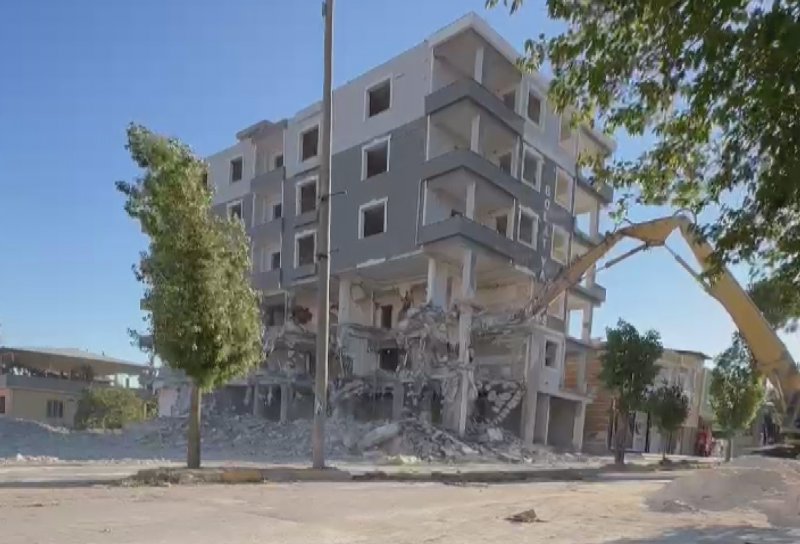 HATAY (İHA) - Hatay'ın Hassa ilçesinde 6 katlı iş merkezinin iş makinesinin darbesiyle kontrollü olarak yıkıldığı anlar kameraya yansıdı.