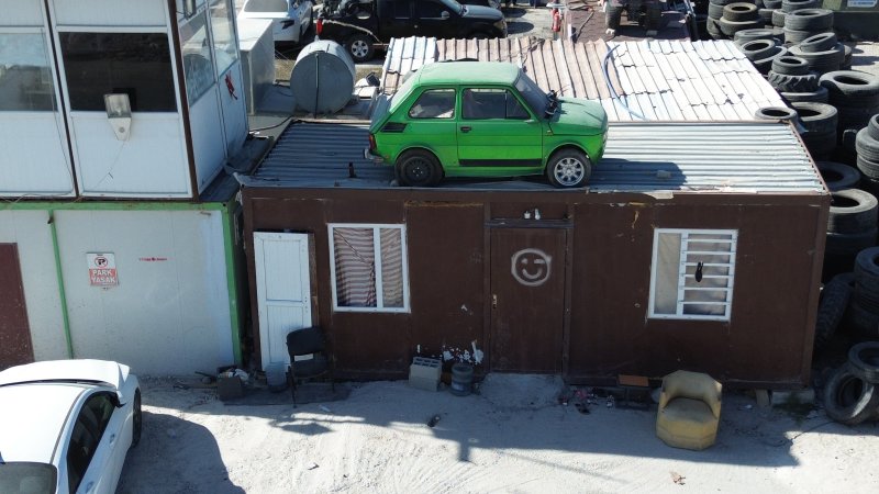 Arkadaşının emanet arabasına zarar gelmesin diye forkliftle konteynerin üzerine koydurdu