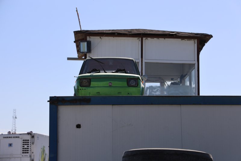 Arkadaşının emanet arabasına zarar gelmesin diye forkliftle konteynerin üzerine koydurdu