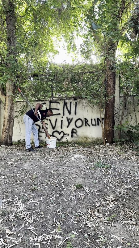 Sevdasını duvara yazan vatandaşa, belediye personelinin "Seviyorsan git konuş" mesajı tebessüm ettirdi (Fotoğraflı) Ahmet Arslan HATAY (İHA) - Hatay'da duvara "Seni Seviyorum" yazarak kalp çizen vatandaşa, belediye personeli "Seviyorsan git konuş bence çünkü biz siliyoruz" diyerek mesaj gönderdi. Belediye personelinin verdiği mesaj ve yazıyı sildiği anlar sosyal medyada ilgi odağı oldu. Antakya Belediyesi, kenti yaşanabilir hale getirmek için çalışmalarını aralıksız sürdürüyor. Kentteki asli görevlerini yerine getiren belediye ekipleri, zaman zaman da farklı olaylarla karşı karşıya kalıyor. Antakya kent merkezinde bir duvara "Seni Seviyorum" yazarak kalp simgesi koyan vatandaşın yazdıkları belediye ekipleri tarafından silindi. Yazının silindiği esnada çekilen görüntü ve Antakya Belediyesi personelinin verdiği "Seviyorsan git konuş bence, çünkü biz siliyoruz" mesajı ise tebessüm ettirdi. O anlar, kısa sürede sosyal medyada ilgi odağı oldu.