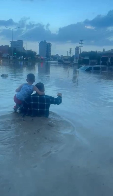 Hatay'da şiddetli yağış: Araçlarında mahsur kalan 25 kişi kurtarıldı (Fotoğraflı) Ogün Aslan HATAY (İHA) - Hatay'ın Payas ilçesinde şiddetli yağış nedeniyle minibüste mahsur kalan 25 kişi, itfaiye ekiplerinin yoğun çalışması sonucu kurtarıldı. Meteoroloji Genel Müdürlüğü'nün şiddetli yağış uyarısında bulunduğu Hatay'ın kıyı ilçelerinde gece saatlerinden itibaren etkili olan sağanak yağış hayatı olumsuz etkiledi. Payas ilçesinde caddeler ve sokaklar adeta göle dönerken, dere yataklarında debi artışı sele neden oldu. Şiddetli yağış nedeniyle Payas ilçesi Şehit Yüzbaşı Ali Oğuz Bulvarı üzerinde kırmızı ışıklarda bekleyen yolcu minibüsü sular altında kaldı. Araçtaki 25 kişi itfaiye ekiplerinin yoğun çalışması sonucu kurtarıldı. Minibüste bulunan kanser hastası bir yolcu ise şoförün ağabeyi tarafından camdan çıkarılarak 112 acil sağlık ekiplerine teslim edildi. Yaklaşık 400 bin TL'lik maddi hasarın oluştuğu araçta mahsur kalan sürücü 27 yaşındaki Şehmuz Yalçın, yaşadıklarını şöyle anlattı: "Beş buçuk arabasıydım, İskenderun-Adana seferi yapıyordum. Payas'a geldiğimde yağmur şiddetini artırdı. Kırmızı ışıkta beklerken aniden su baskını oldu. Araç istop etti, kapıları açamadık çünkü su yükseliyordu. İçeride 25 yolcu vardı. Ağabeyimi aradım, hemen yardıma geldi. Bir kanser hastası yolcumuz vardı, onu camdan çıkarıp ambulansa teslim ettik. Daha sonra kepçeyle tahliye edildik. Aracım tamamen kullanılamaz hale geldi, 350-400 bin TL civarında zararım var."