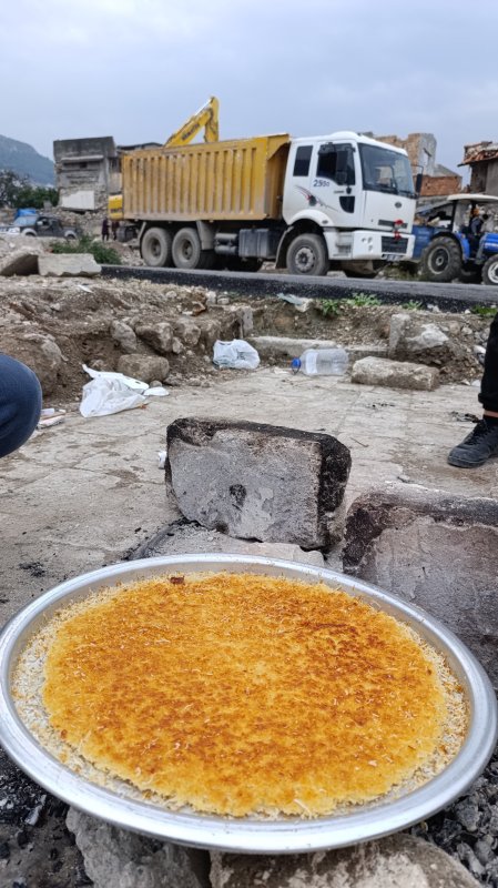  Kepçenin kovasında künefe çeviren operatörün o anları ilgi odağı oldu - Mehmet Topal: "O kadar künefe yedim ve çevirdim ama bu unutulmaz bir an oldu" (Fotoğraflı) Ramazan İlın HATAY (İHA) - Hatay'da kepçe operatörü Mehmet Topal'ın ekskavatörün kovasının üzerinde tescilli lezzet künefeye takla attırdığı anlar sosyal medyada ilgi odağı oldu. Antakya ilçesinde 32 yaşındaki kepçe operatörü Mehmet Topal, hasarlı binalarının yıkımını gerçekleştiren bir yıkım ekibinde mesai yapıyor. İl dışından Hatay'a gelen arkadaşlarına tescilli lezzet künefeyi tattırmak isteyen Topal, künefeye ekskavatörün kovasının üzerinde takla attırdı. Topal'ın sosyal medyada paylaşılan anları ilgi odağı olurken arkadaşlarına da moral oldu. “O kadar künefe yedim ve çevirdim ama bu unutulmaz bir an oldu” Ekskavatörün kovasının üzerinde künefeyi çevirmeyi başaran Mehmet Topal, “Künefeyi her zaman yapan ve seven biriyimdir. O gün de iş arkadaşlarıma yapmak istedim. Başka şehirden gelen arkadaşlarımıza orijinal Hatay künefesi yedirmek istedim. Künefeyi iş yerinde yaptık. Arkadaşlarımıza közde künefe yedirdik. Künefeyi ekskavatörün üstünde atma fikri de kuzenimden geldi. Biraz eğlence katalım dedi. Bu enkaz yığınların arasında bize moral olsun istedik. Künefeyi ekskavatörün üzerindeyken atarak çevirdik. O kadar künefe yedim ve çevirdim ama bu unutulmaz bir an oldu. Atamasaydım rezil olurdum ama çok şükür şimdiye kadar atamadığımız olmadı. Güzel de oldu. ekskavatör üzerinde de farklılık oldu ve iyi ki de oldu” dedi. “Bize renk kattı ve güzel enerji oldu” Kuzeninin yaptığı davranışla ortama neşe kattığını söyleyen Muhammed Topal, “Bu defa farklı bir şeyler olsun ve ortama neşe katalım dedim. Onu da ekskavatörün üzerinde denedik ve güzel de oldu. Künefeyi parçalanmadan çevirdik. Bize renk kattı ve güzel enerji oldu. Hatay'ımızın meşhur künefesinin tadı da güzeldi” ifadelerini kullandı.