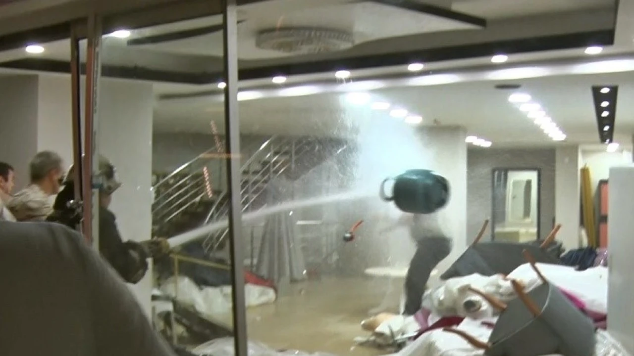 Eşinin mağazasına girip gelinliklerin üzerlerine kolonya döktü, tüpe çakmağı dayayınca tazyikli suyu yedi