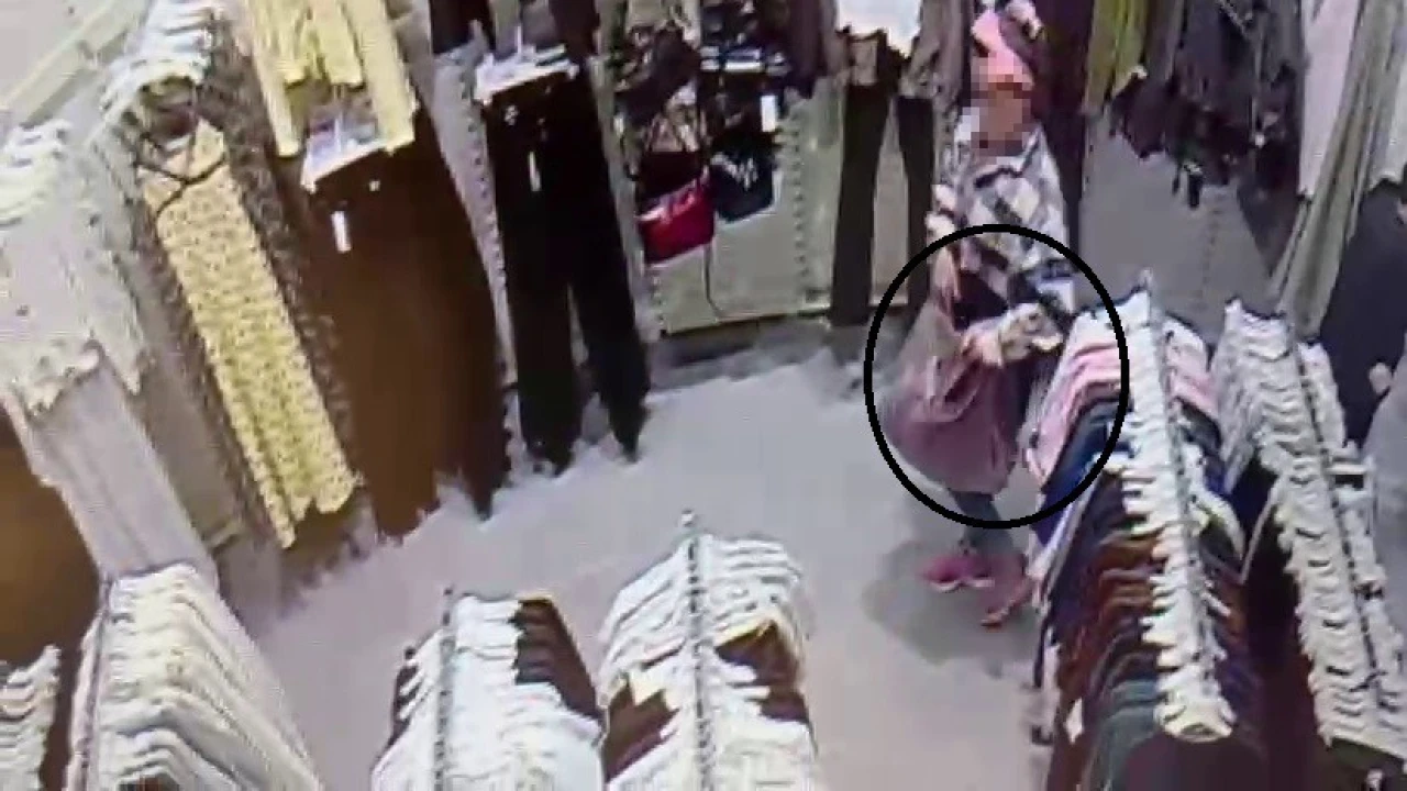 Alışveriş merkezinde çocuğunun yanında hırsızlık yapan kadın kamerada