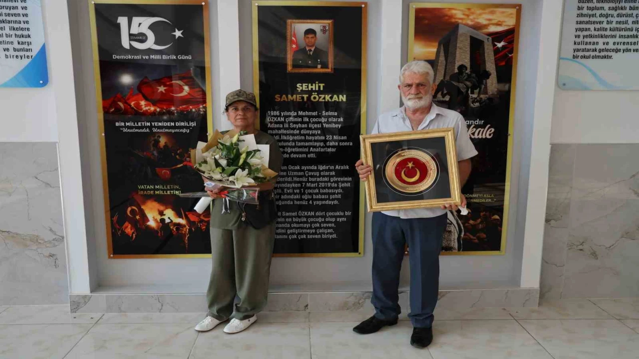 Şehit anne ve babası Türk bayrağıyla okulda