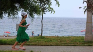 Konyaaltında denizin keyfini çıkartan vatandaşlara yağış sürprizi