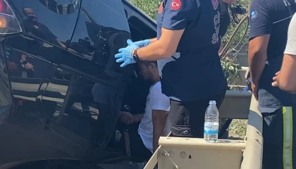 Takla atan araçta sıkıştı, telefonları elinden bırakmadı