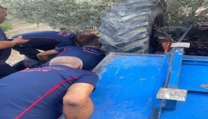 Devrilen traktörün altında kalan sürücüyü kurtarmak için zamanla yarıştılar