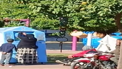 Giysi kumbarasına giren çocuk, topladığı kıyafetleri annesine verdi