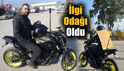 Sırtına bağladığı kartonla şehri dolaşan motosikletli ilgi odağı oldu