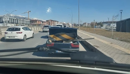 Karayolu işaret levhasını otomobil ile taşıdı