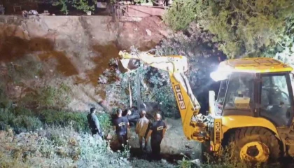 Düştüğü su kanalında çamura saplanan inek, kepçeyle kurtarıldı