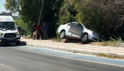 Kaldırıma çıkıp asılı kalan otomobildekiler kazayı burnu bile kanamadan atlattı