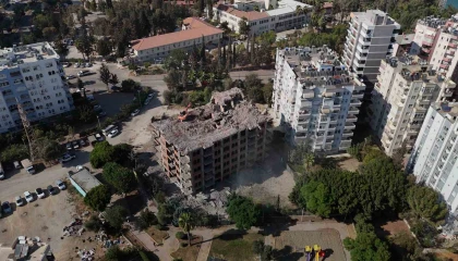 Adanada yaklaşık 33 yıl önce inşaatına başlanan 11 katlı bina, damına iş makinesi çıkartılarak yıkılıyor