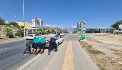 Yakıtı biten otomobili polis ve vatandaşlar iterek akaryakıt istasyonuna götürdü