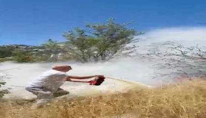 Yangını görüp aracındaki yangın tüpüyle muhtemel orman yangınının önüne geçti