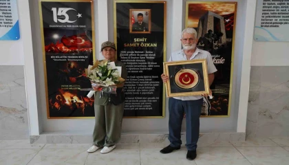 Şehit anne ve babası Türk bayrağıyla okulda