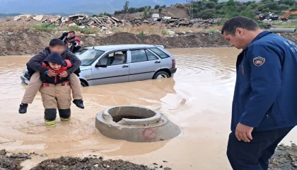 İtfaiyeci, göle dönen yolda mahsur kalan çocuğu sırtında taşıyarak kurtardı